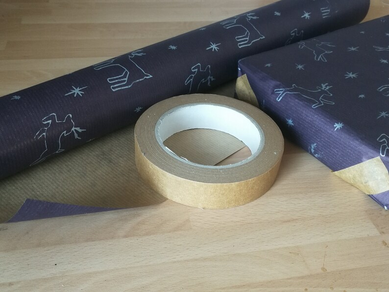 May include: A roll of brown paper with a white deer pattern, a roll of dark blue paper with a white deer pattern, and a roll of brown tape.