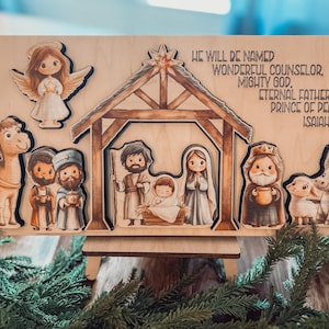 May include: Wooden nativity scene puzzle with cutout figures of the Holy Family, angels, and animals. The text "WE WILL BE NAMED WONDERFUL COUNSELOR, MIGHTY GOD, ETERNAL FATHER, PRINCE OF PEACE, ISAIAH 9:6" is printed on the wood.