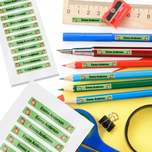 May include: A sheet of green and white personalised name labels with a monkey graphic. The labels say "Emma Anderson" and are shown on a variety of school supplies, including pencils, pens, a ruler, and a pencil sharpener.