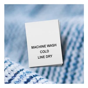 May include: White care label with black text that reads "Machine Wash Cold Line Dry"