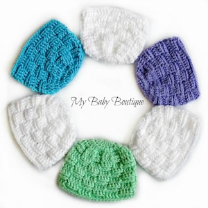 May include: Six crocheted baby hats in a circle. The hats are in the colors white, teal, purple, green, and white. The hats have a woven pattern. The text "My Baby Boutique" is in the center of the circle.