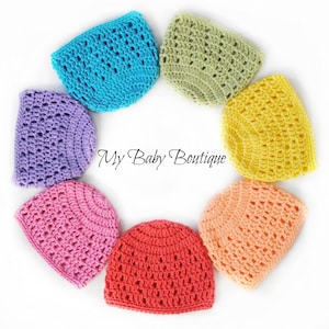 May include: A set of seven crocheted baby hats in various colors, including purple, pink, peach, red, yellow, green, and blue. The hats are arranged in a circle on a white background. "My Baby Boutique" is written in the center of the circle.