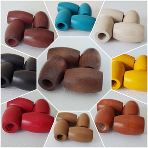May include: Assortment of wooden barrel-shaped beads in various colors, including red, brown, black, blue, beige, yellow, and orange. The beads are approximately 2 inches long and 1 inch in diameter.