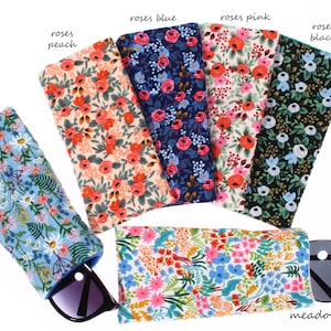 May include: Six different floral patterned eyeglass cases with the names "wildflowers", "roses peach", "roses blue", "roses pink", "roses black", and "meadow".