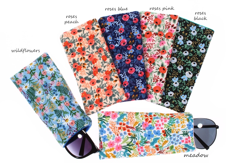 May include: Six different floral patterned eyeglass cases with the names "wildflowers", "roses peach", "roses blue", "roses pink", "roses black", and "meadow".
