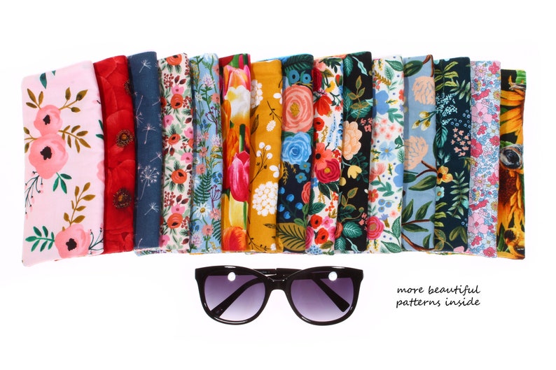 May include: A set of 14 colorful fabric eyeglass cases with floral patterns. The cases are arranged in a row, with the top edge of each case facing the viewer. The cases are all different colors and patterns, but they all have a similar floral design. The text "more beautiful patterns inside" is written below the cases.