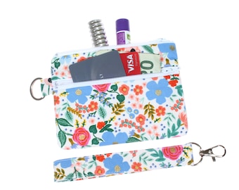Estuche con doble cremallera y diseño floral de Rifle Paper: llavero, billetera y porta identificación.