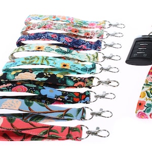 May include: A set of 10 colorful floral patterned keychains with silver swivel clips. The keychains are made of fabric and are approximately 18 inches long. The keychains are arranged in a row, with the top keychain at the top of the image and the bottom keychain at the bottom of the image.