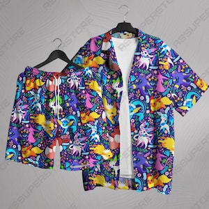 May include: A matching set of Hawaiian shirt and shorts featuring a vibrant pattern of colorful cartoon characters on a dark purple background. The shirt is open, revealing a white undershirt. The shorts have a drawstring.
