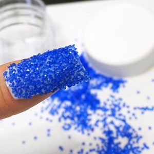 Royal blue crystals on nail.