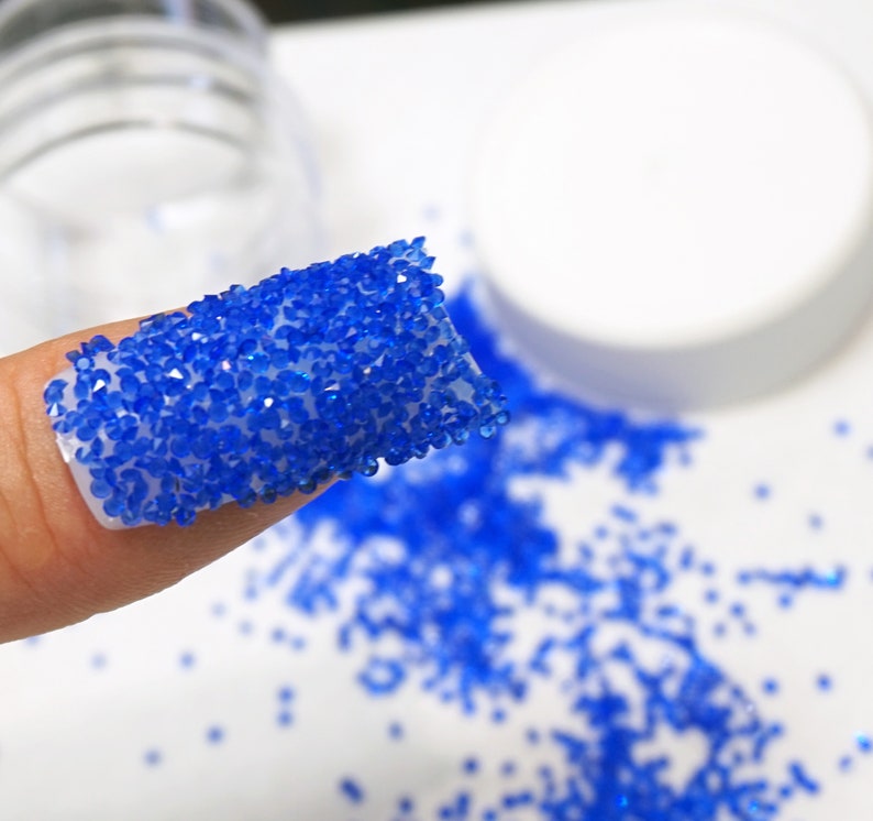 Royal blue crystals on nail.