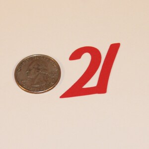 May include: Red paper number 21, approximately the size of a US quarter.