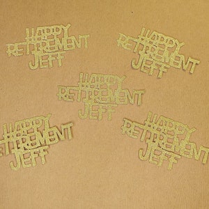 K&ouml;nnte beinhalten: F&uuml;nf goldene Glitzer-Papierschnitte, die auf braunem Hintergrund "Happy Retirement Jeff" sagen.