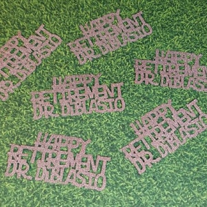 K&ouml;nnte beinhalten: Sechs rosa Glitzer-Papierschnitte mit dem Text "Happy Retirement Dr. DiBlasio".