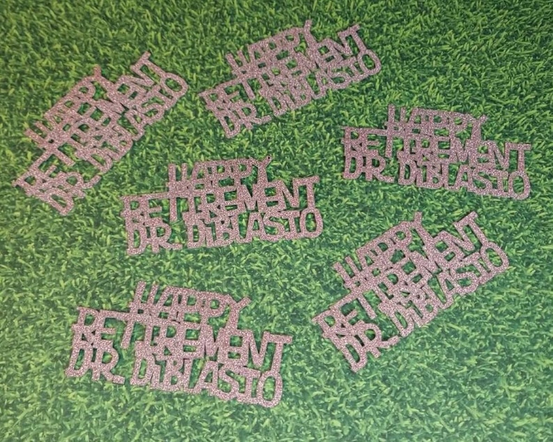 K&ouml;nnte beinhalten: Sechs rosa Glitzer-Papierschnitte mit dem Text "Happy Retirement Dr. DiBlasio".