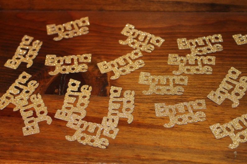 May include: Gold glitter confetti with the name "Emma Jade" repeated on each piece.