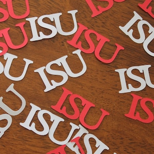 May include: A close-up of a wooden surface covered with red and white paper cutouts of the letters "ISU".