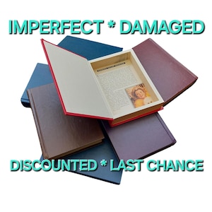May include: A stack of four hardcover books with a red book on top. The red book is open and has a white page with text and a photo of a woman. The text on the red book says "IMPERFECT * DAMAGED DISCOUNTED * LAST CHANCE".