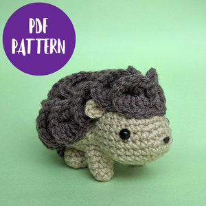 May include: Crocheted hedgehog amigurumi toy with brown yarn for the quills and beige yarn for the body. The toy has black eyes and a small black nose.