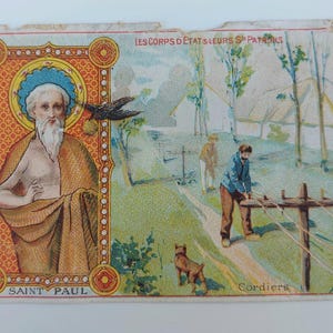 May include: Vintage religious card featuring Saint Paul with a halo, a bird, and a landscape scene. The card has text in French and is likely from a collection of religious ephemera. The colors are muted, with a focus on the central figure.