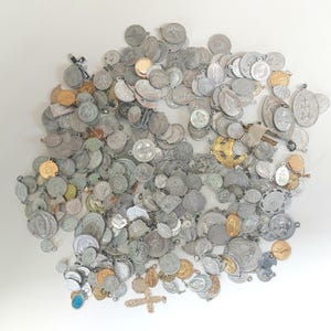 Peut inclure: Une grande collection de médailles et pendentifs religieux assortis de formes et de tailles variées. Les articles sont principalement en métal argenté, avec quelques pièces dorées et bronzées. Beaucoup présentent des figures et symboles en relief.