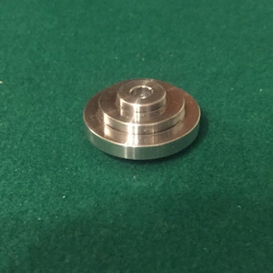 Peut inclure: Une bague en métal argenté avec trois anneaux empilés, chacun ayant un diamètre légèrement plus petit que celui en dessous.