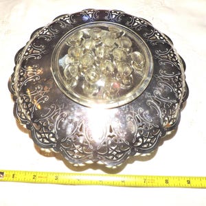 May include: Silver-plated decorative serving dish with a glass insert and intricate filigree design.