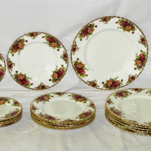 May include: A set of 10 white porcelain plates with a gold rim and floral pattern. The plates are in various sizes, including dinner plates, salad plates, and bread and butter plates.