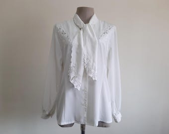 Vintage jaren 80 witte blouse met strik in de hals, geborduurd, met kant en opengewerkt patroon, lange mouwen, maat S.