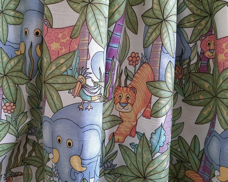 May include: Fabric with a jungle-themed pattern featuring cartoon animals like tigers, elephants, and giraffes. The design includes palm trees, flowers, and a bird. The color palette includes shades of green, orange, blue, and pink.