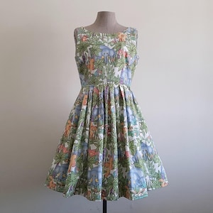 May include: A sleeveless, knee-length dress with a whimsical jungle animal print. The dress features a fitted bodice and a flared skirt. The print includes elephants, monkeys, and other animals amidst lush green foliage. The dress is displayed on a mannequin.