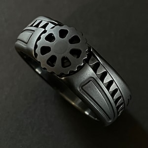 The Watchman Midnight - A titanium rack and pinion wearable machine in a black satin finish. A ring that combines precision motion with art.