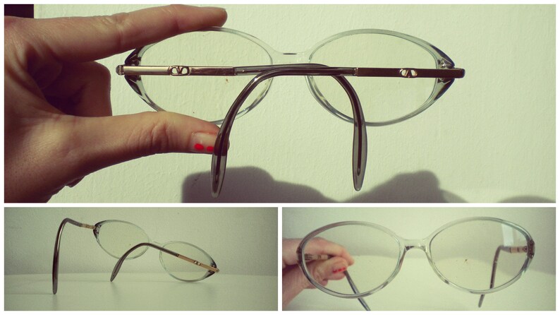 May include: Two pairs of clear plastic eyeglasses with thin metal arms. The first pair has a dark gray bridge and the second pair has a silver bridge.