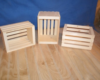 May include: Three wooden crates, each with a different size and shape. The crates are made of natural wood and have a rustic look. They are perfect for storing and displaying items.