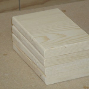 May include: A stack of three unfinished wooden boards with a smooth, light wood grain.