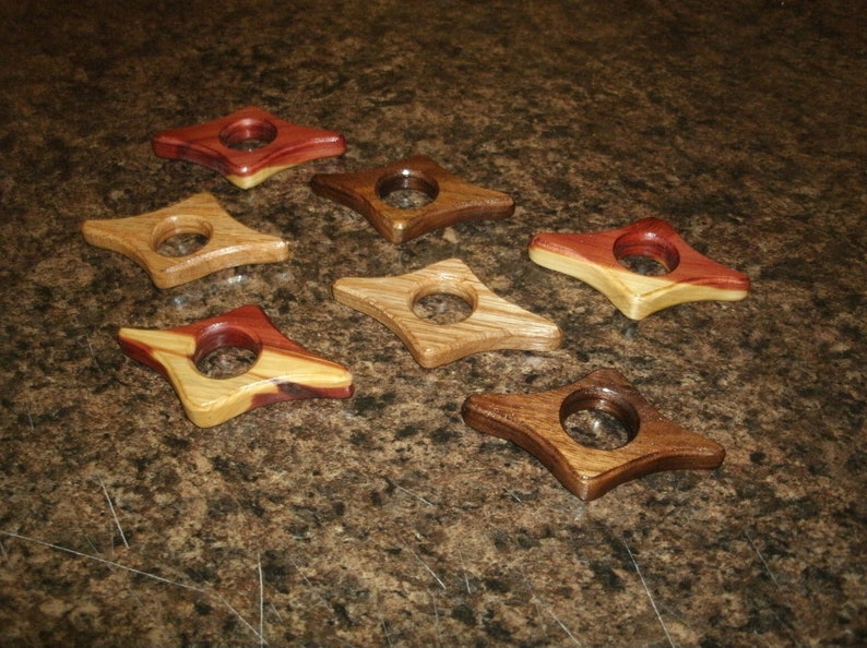 Puede incluir: Ocho sujetalibros de madera en varios tonos y patrones de madera. Cada sujetalibros tiene forma de diamante con un agujero redondeado en el centro.
