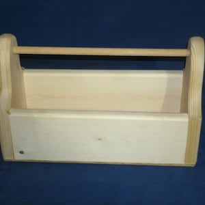 May include: A plain wooden tool box with a handle. The box is made of light wood and has a simple design.