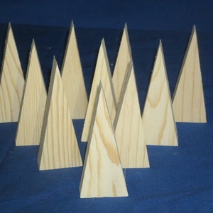 May include: Ten wooden triangle shapes, resembling miniature Christmas trees, arranged in a staggered pattern on a blue surface.