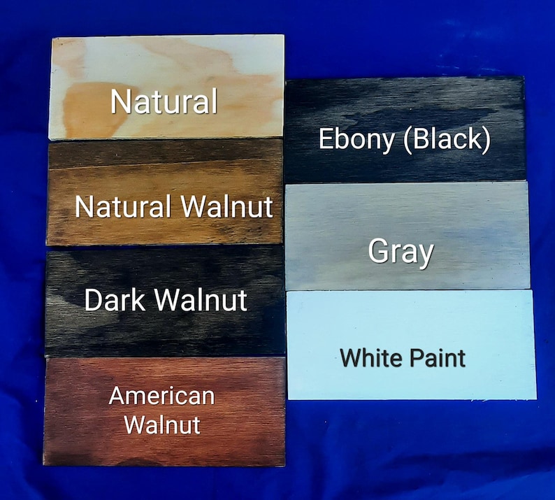 Puede incluir: Cinco muestras de madera que muestran diferentes manchas de madera: Natural, Nogal natural, Nogal oscuro, Nogal americano, &Eacute;bano (negro), Gris y Pintura blanca.