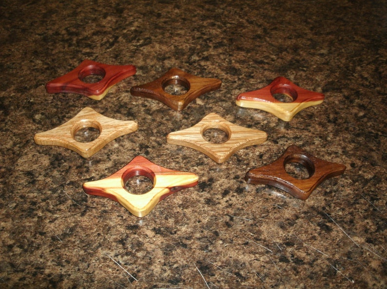 Puede incluir: Siete sujetalibros de madera con forma de estrella y un agujero en el centro. Los sujetalibros est&aacute;n hechos de diferentes tipos de madera, incluyendo cedro y nogal. Los sujetalibros son de diferentes colores, incluyendo rojo, marr&oacute;n y madera natural.