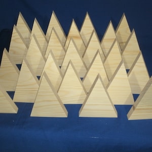 May include: A set of 18 unfinished wooden triangles, arranged in a staggered pattern, with the points facing upwards. The triangles are all the same size and shape, and they are made of a light-colored wood.