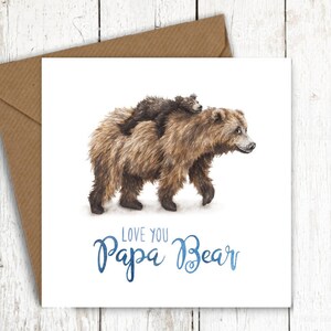 Peut inclure: Une carte blanche avec une illustration aquarelle d'un ours brun avec un petit ourson brun mont&eacute; sur son dos. Le texte "Love you Papa Bear" est &eacute;crit en bleu sous les ours.