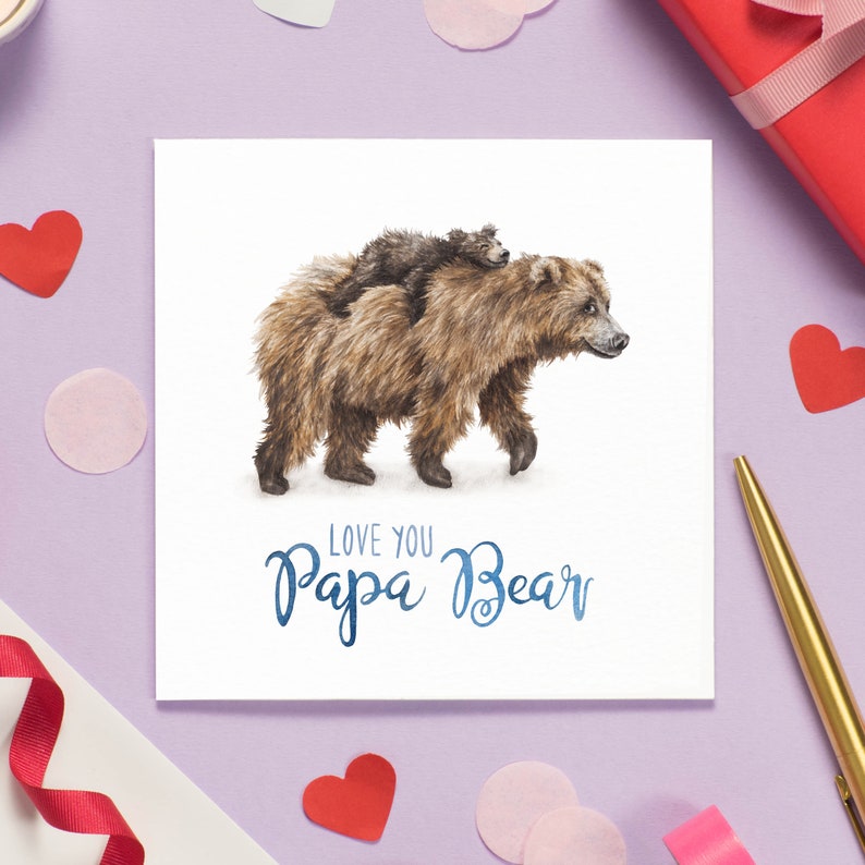 Peut inclure: Une carte blanche avec une illustration aquarelle d'un ours brun avec un petit ourson brun mont&eacute; sur son dos. Le texte "Love you Papa Bear" est &eacute;crit en bleu sous les ours.