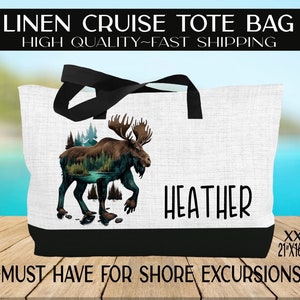 May include: A white linen tote bag with black handles and a black bottom border. The bag features a graphic of a moose with a forest scene inside its silhouette. The text "HEATHER" is printed in black below the graphic. The bag is labeled "XXL 21"x16"x6" and "~MUST HAVE FOR SHORE EXCURSIONS~".