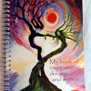May include: A colorful spiral bound journal with a painting of two trees intertwined. The trees are painted in shades of purple, blue, green, red, and yellow. The text on the cover reads "My book of inspirations, dreams and wishes".