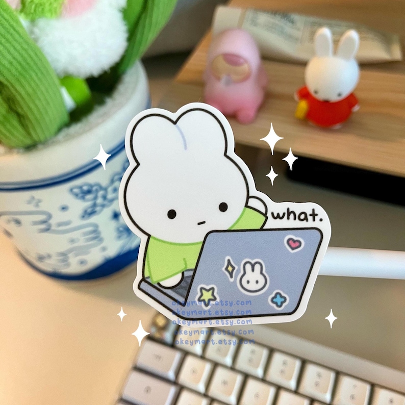 cute white bunny in a green shirt typing on the laptop keyboard confused about a work email and saying what