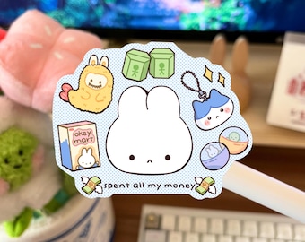 May include: A sticker sheet with various cute illustrations. Includes a large white bunny, a yellow creature, green boxes, a blue cat, and a small box of "okey mart" milk. The text "spent all my money" is also present.
