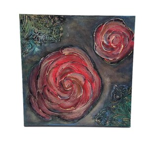 May include: Square canvas art featuring three red rose paintings with textured brushstrokes. The roses are set against a dark gray background with teal and gold decorative accents in the corners. The artwork is a close-up of the roses.