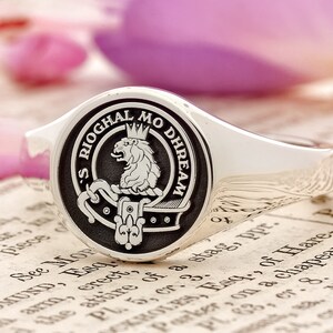 May include: A silver signet ring with a black enamel crest featuring a lion and the text "'S RIOGHAL MO DHREAM".