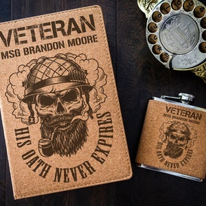 May include: A cork-covered notebook and flask with a skull and crossbones design. The notebook says "Veteran MSG Brandon Moore His Oath Never Expires". The flask says "Veteran MSG Brandon Moore His Oath Never Expires".